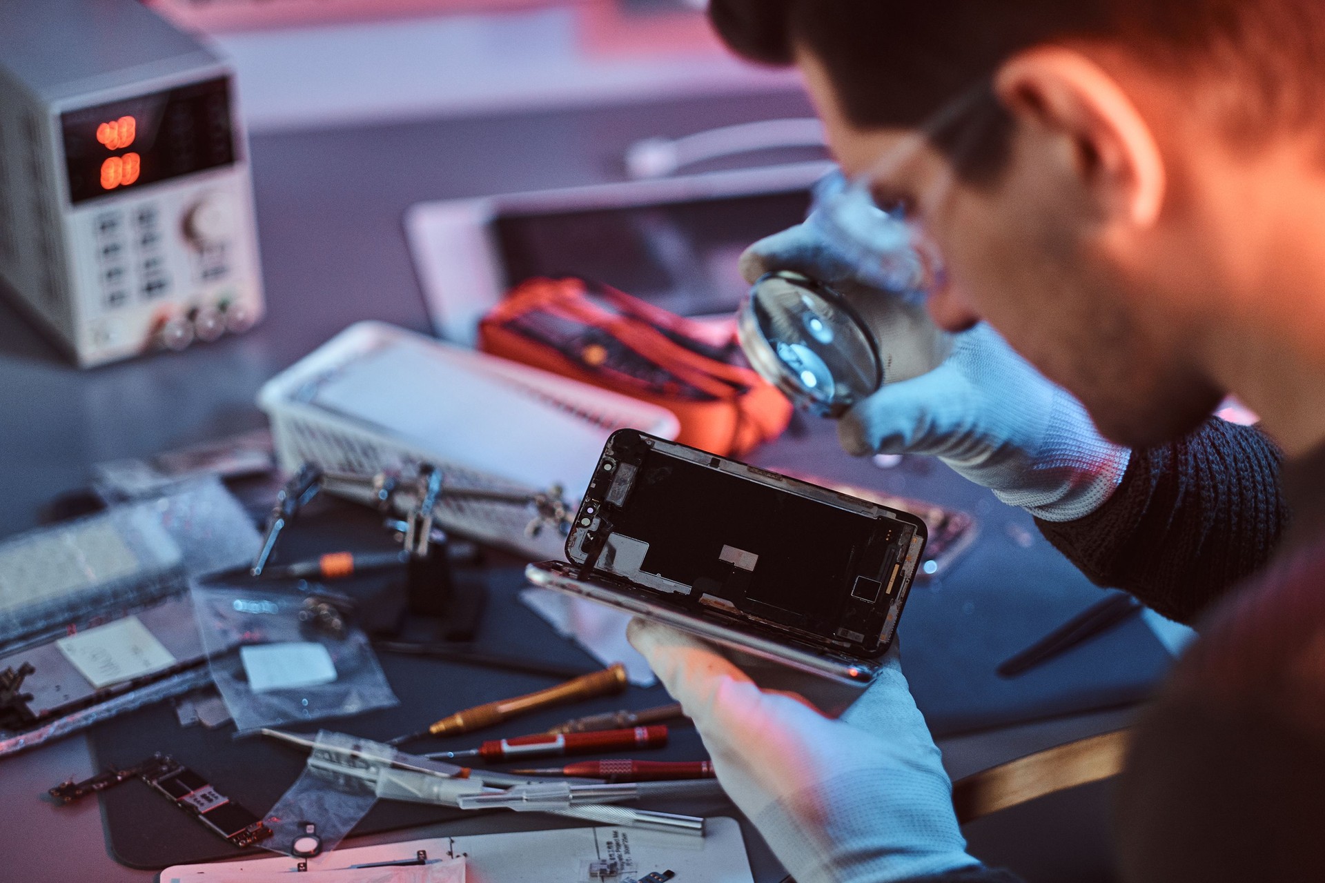Technician carefully examines the integrity of the internal elements of the smartphone in a modern repair shop